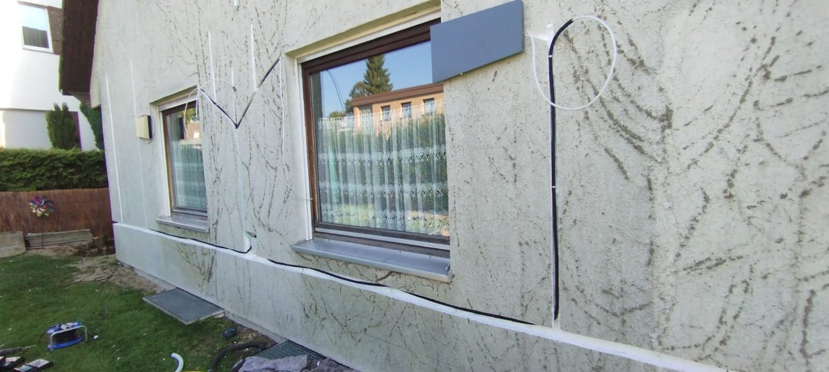 Hausfassade mit zwei dezentralen Lüftungsgeräten: je eine flache Außenhaube neben dem Fenster