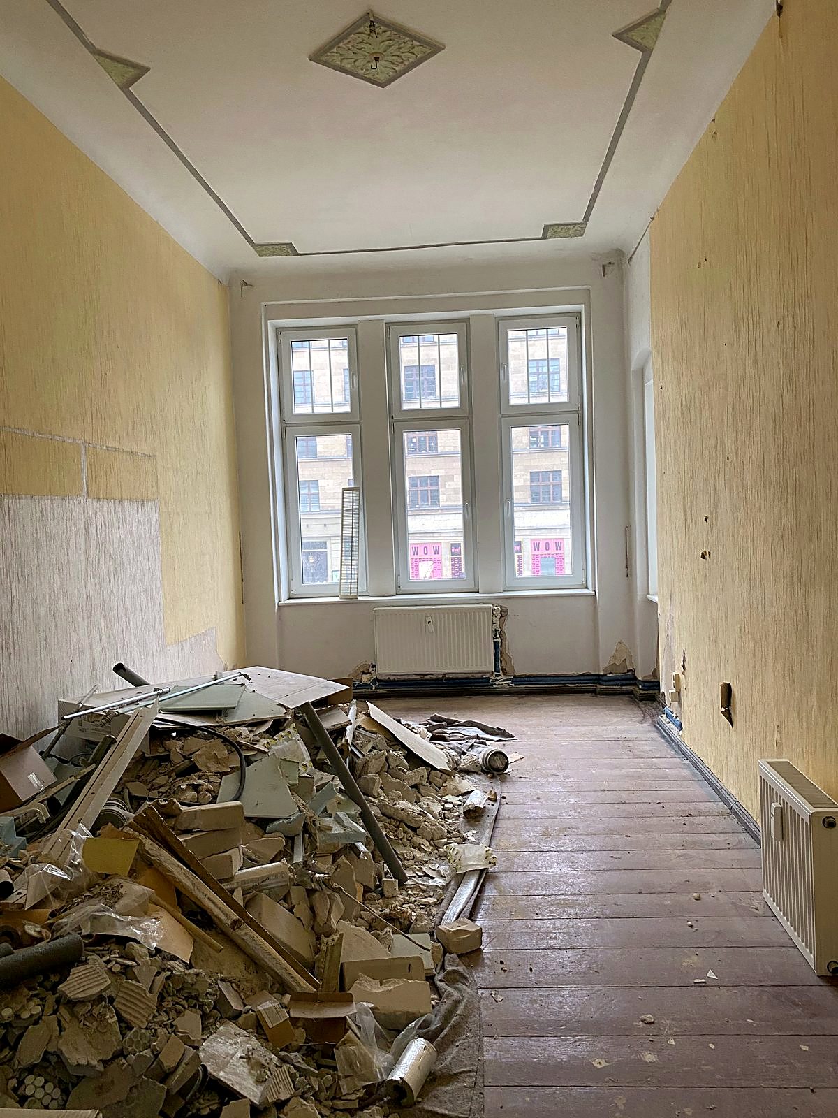 Bauschutt und alte Gipsplatten in einem entkernten Altbauzimmer vor dem Abtransport