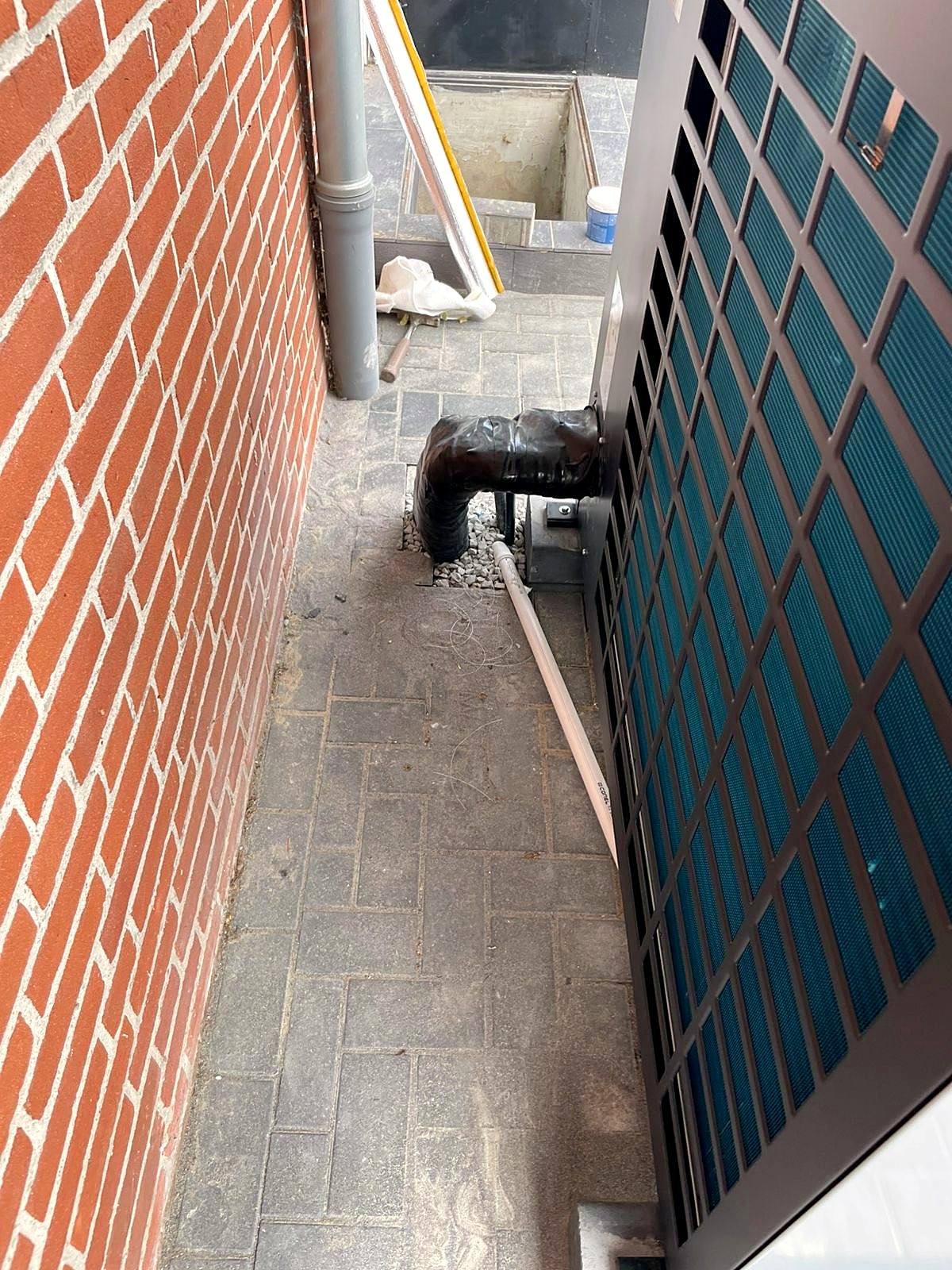 Luft-Wasser-Wärmepumpe an der Klinkerfassade eines Wohnhauses