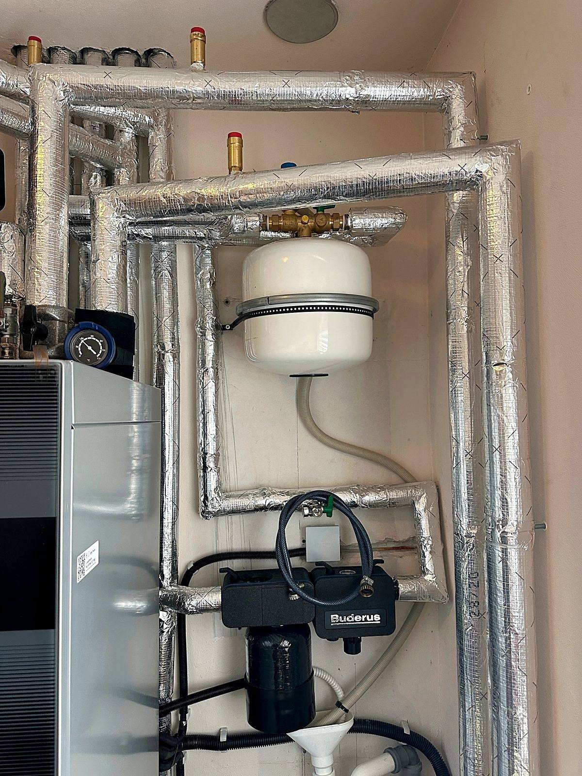 Wärmepumpen-Inneneinheit mit gedämmten Rohrleitungen und Schmutzfilter in einem Bestandskeller