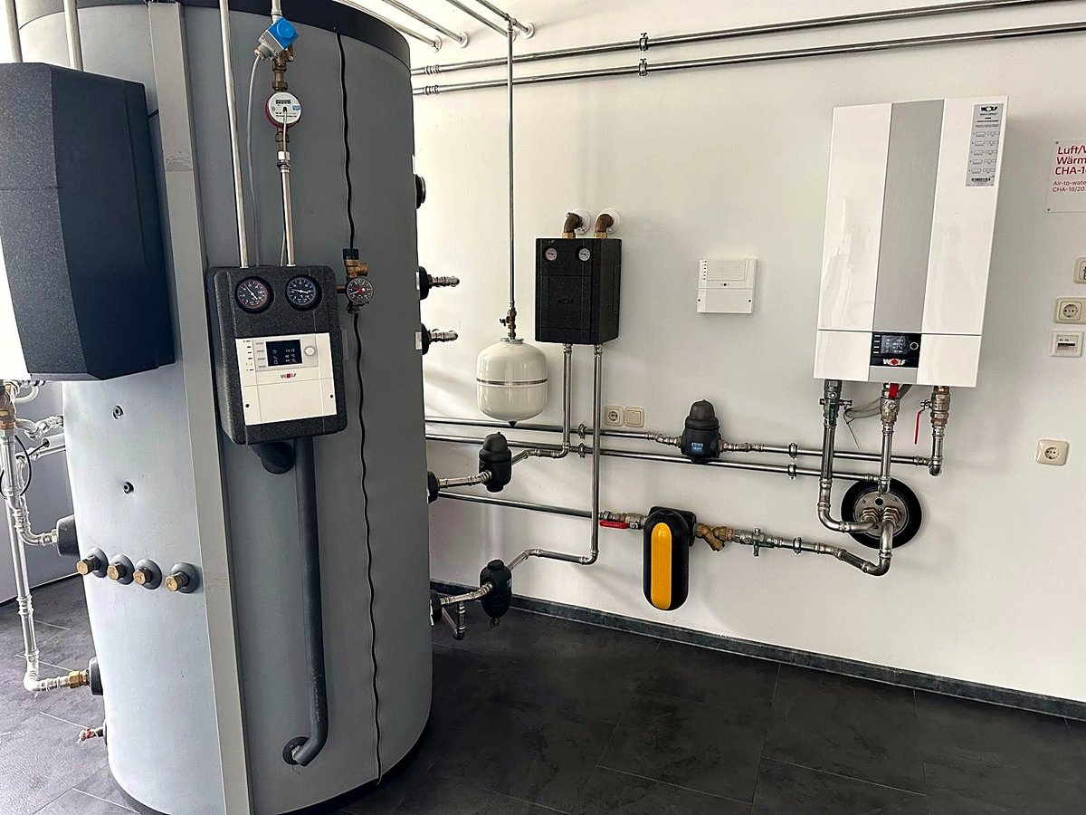 Wandhängende Wärmepumpen-Inneneinheit mit Warmwasserspeicher und Ausdehnungsgefäß im Technikraum