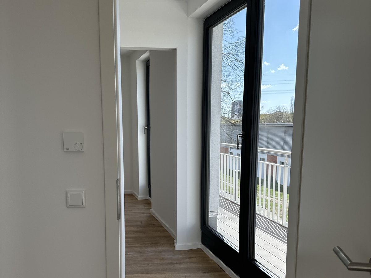 Fertiger Flur mit Türdurchgang und bodentiefem Fenster