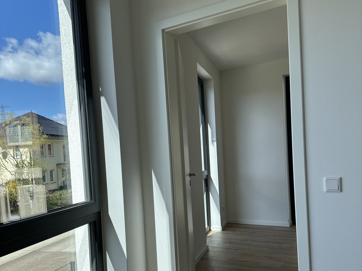 Fertiger Flur mit Türdurchgang, Vinylboden und bodentiefem Fenster