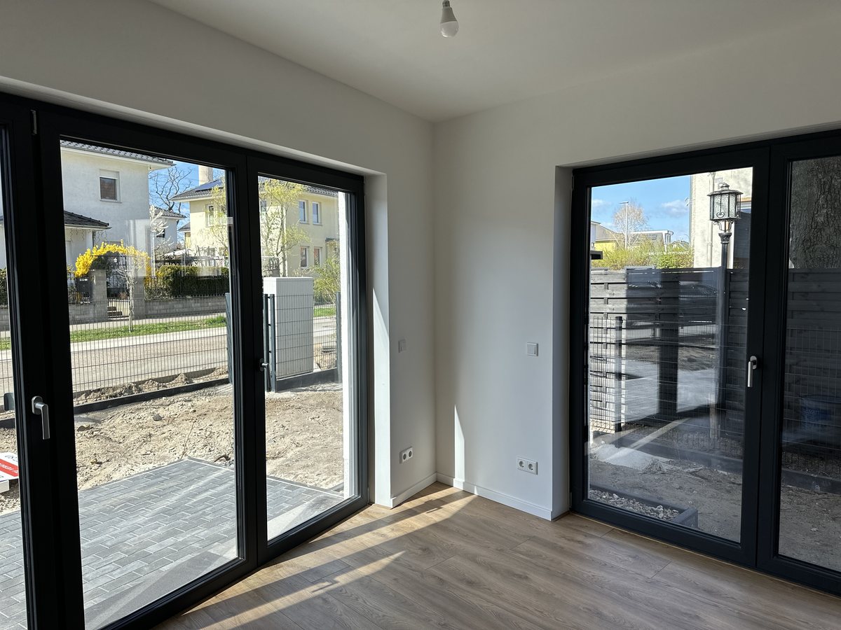 Fertiger Wohnraum mit bodentiefen Fenstern und Vinylboden