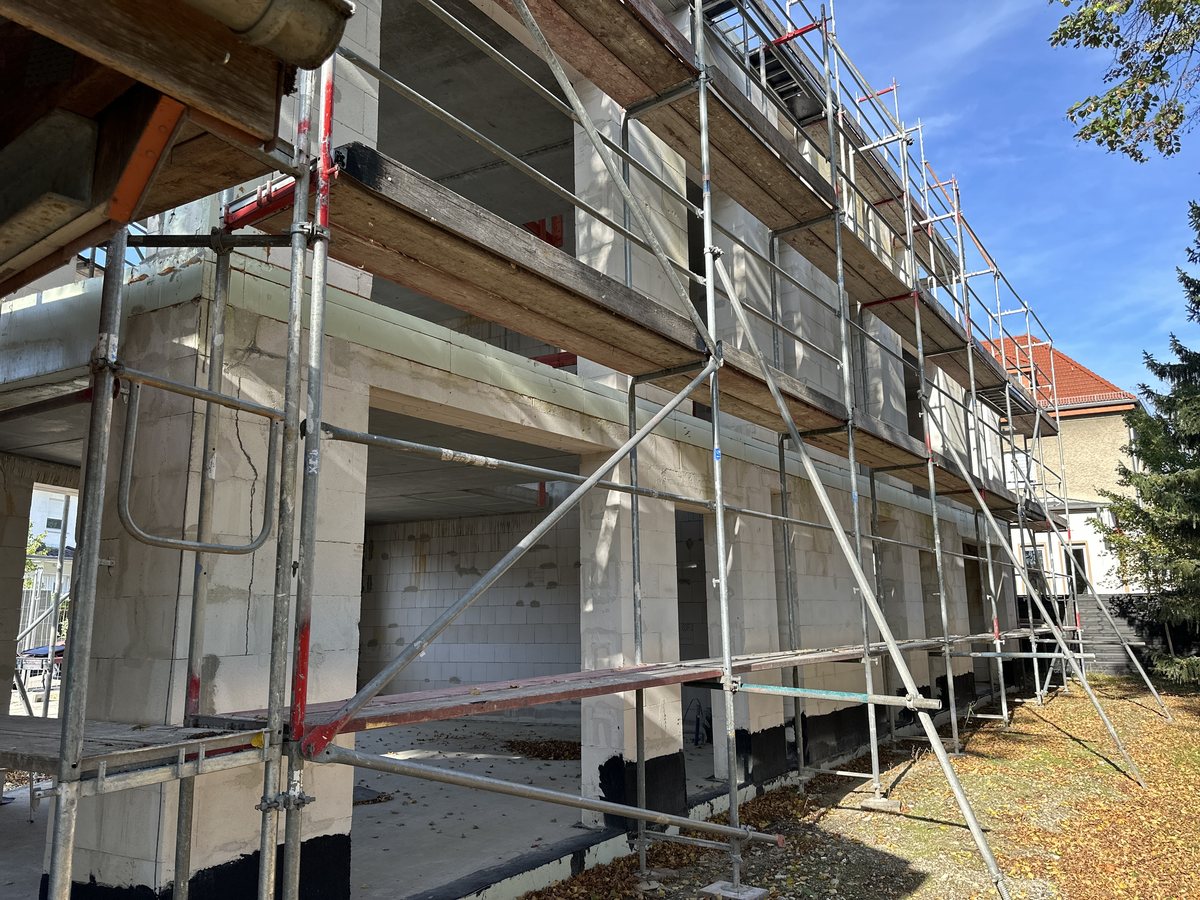 Zweigeschossiger Rohbau mit Gerüst, fertigen Betondecken und Sockelabdichtung