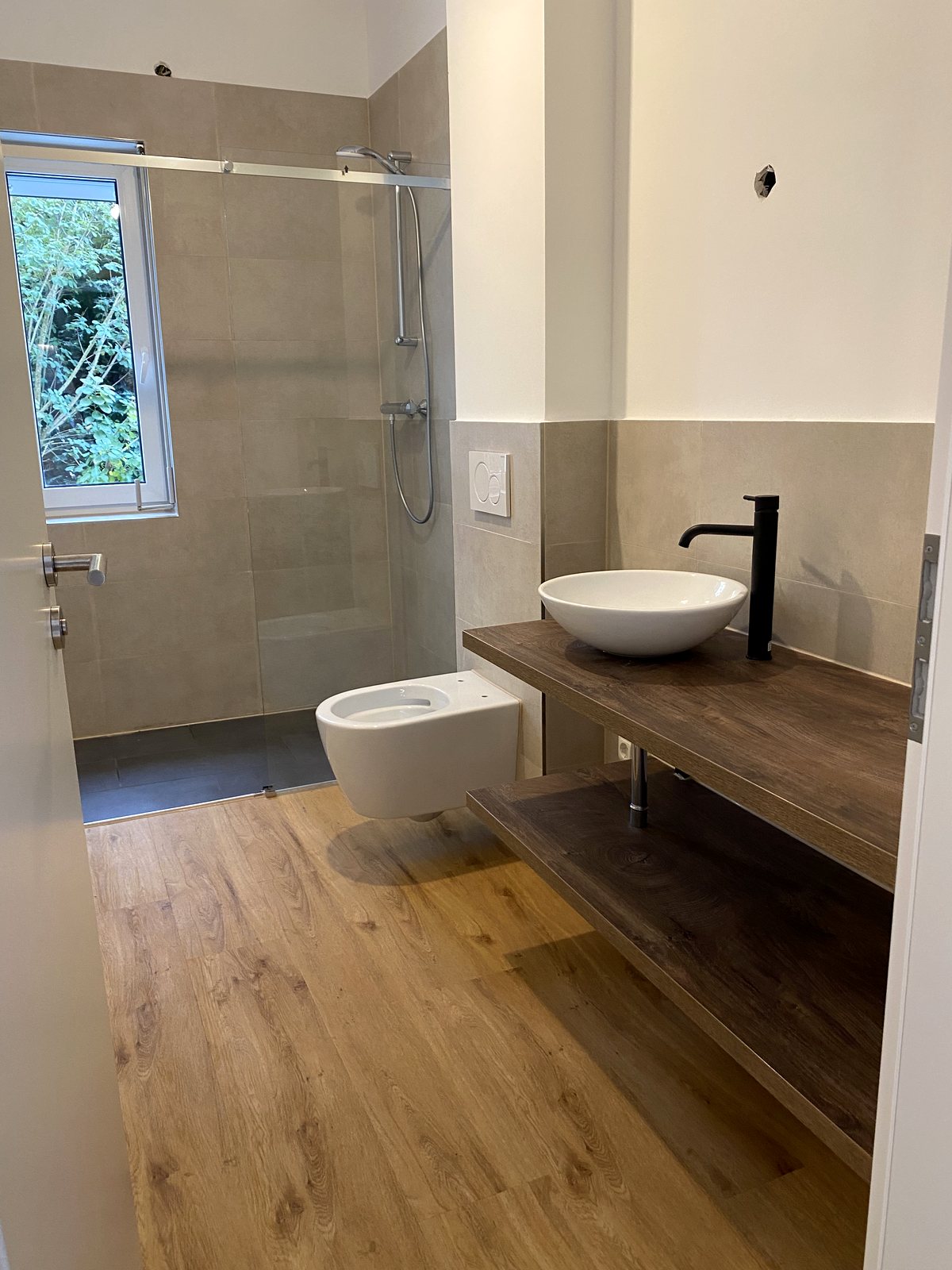 Fertiges Bad mit bodengleicher Dusche und Waschtisch auf Holzkonsole