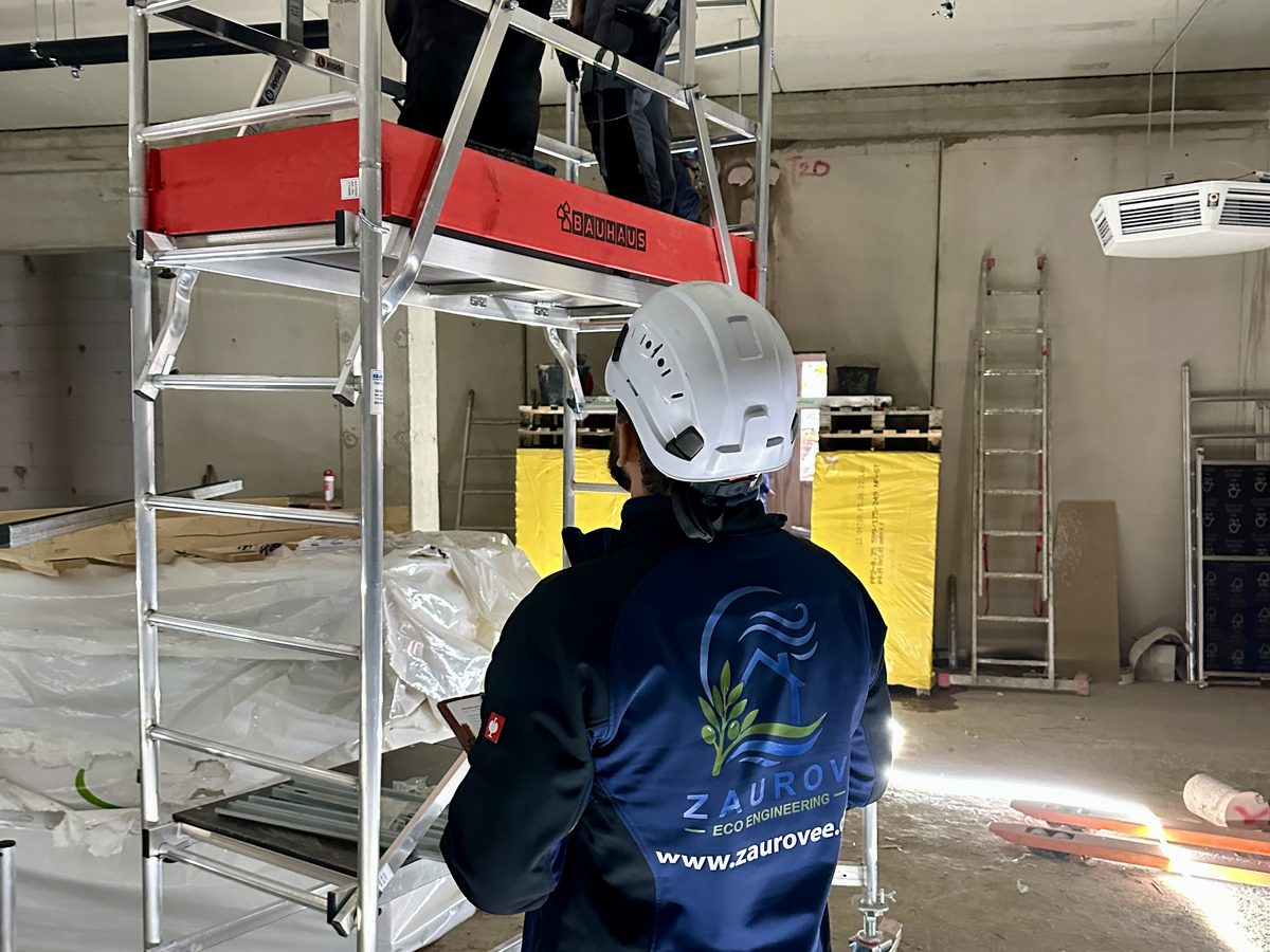 Mitarbeiter von Zaurov Eco Engineering am Rollgerüst beim Innenausbau, Kollege arbeitet an der Decke