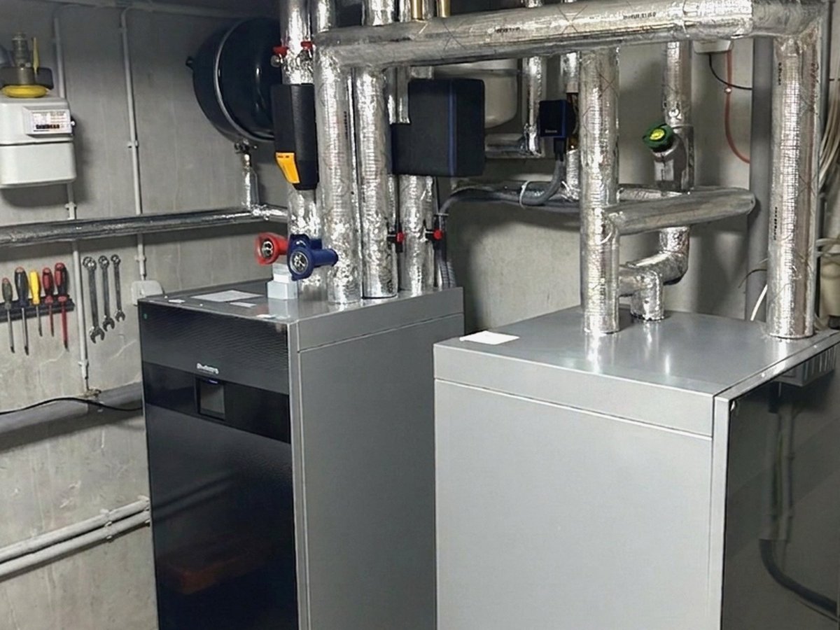 Technikraum mit Wärmepumpen-Inneneinheit, Pufferspeicher und gedämmter Verrohrung