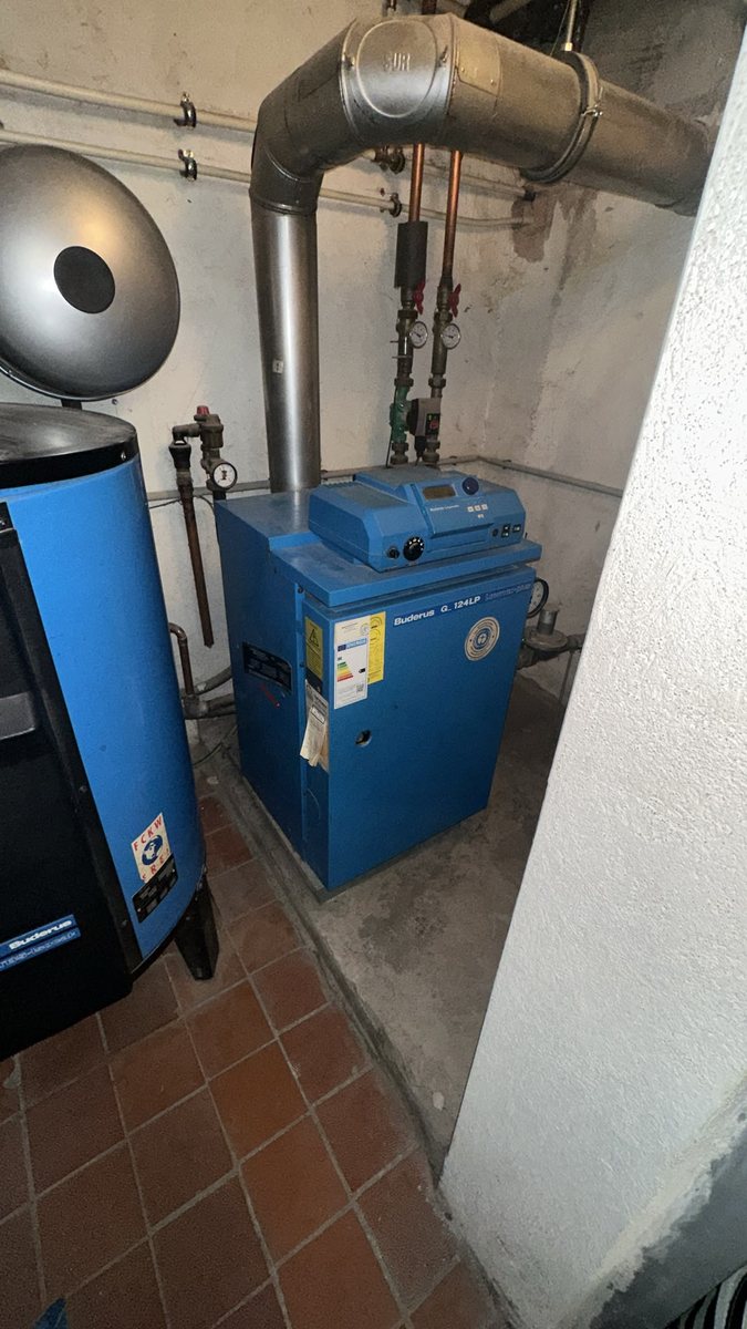 Alter Gaskessel im gefliesten Heizungsraum vor dem Austausch